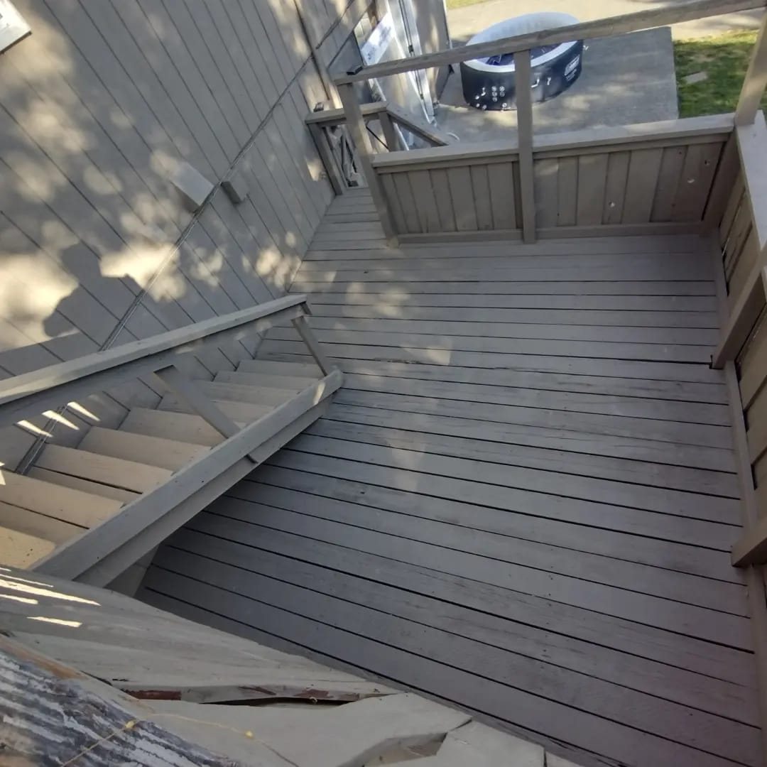 The same wood deck after Curb Appeal power washed and restored it, boards even and clean down the stairs