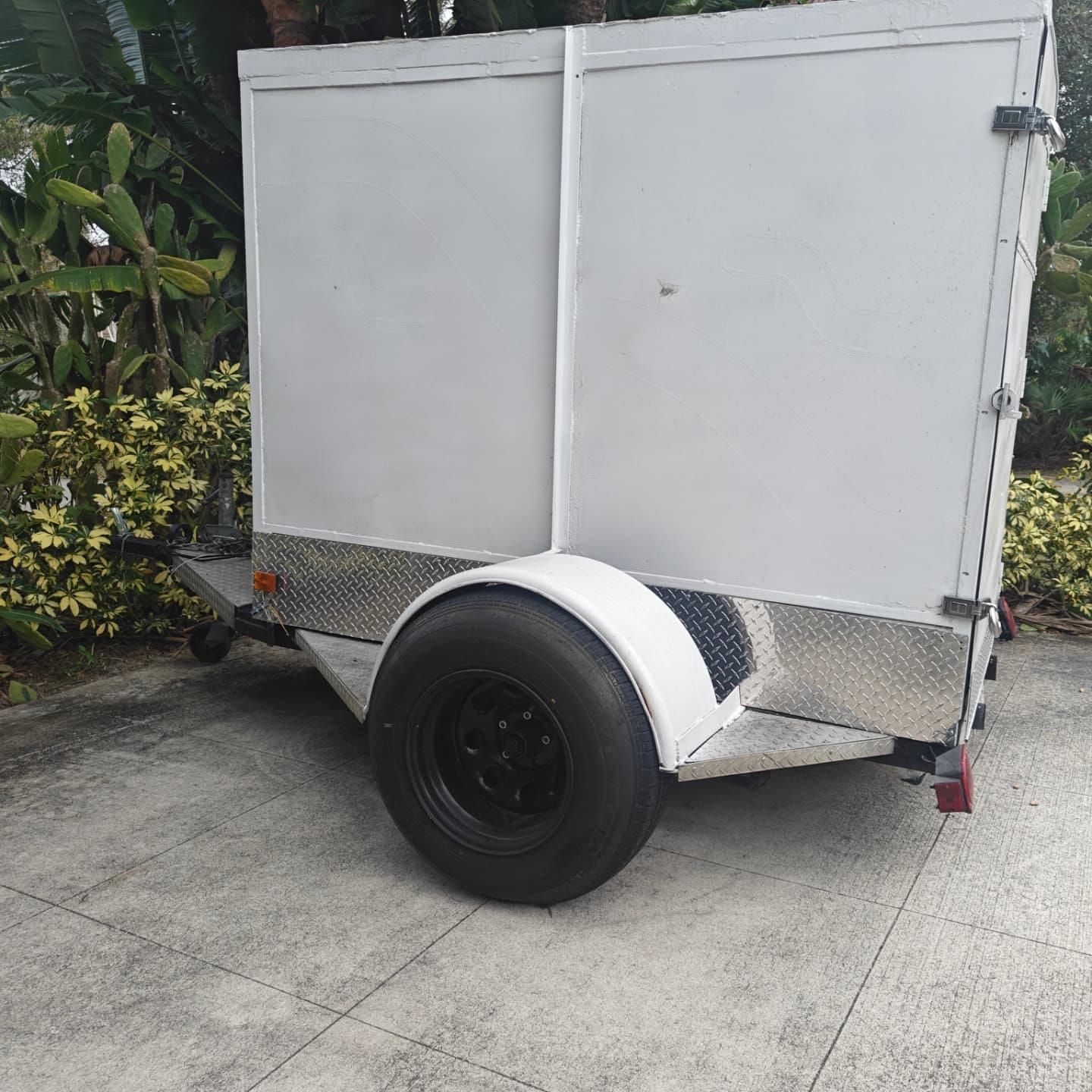 The same enclosed trailer after Curb Appeal stripped, treated, and repainted it white